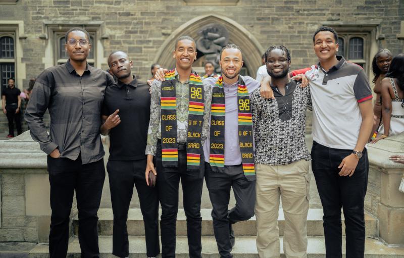 A group of young Black men pose together outside at Black Graduation.