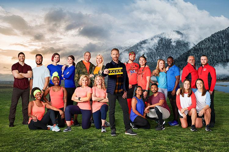 The 20 Amazing Race Canada contestants pose, in pairs, grouped before a mountain backdrop.