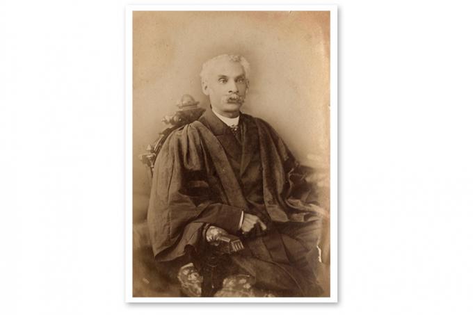 Photo of Anderson Abbott sitting in a chair wearing academic robes.