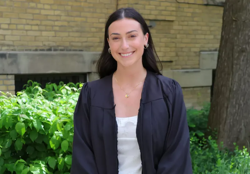 Breanna Vasko standing outside wearing a convocation gown