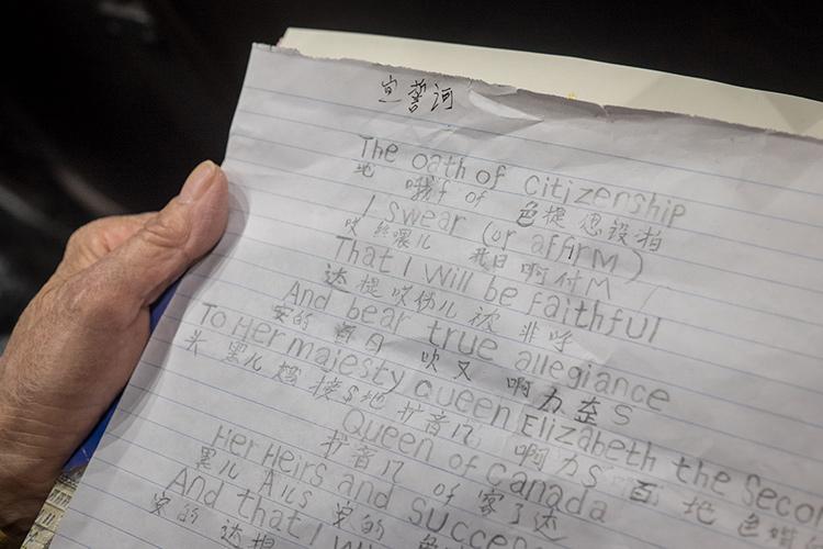 A woman studies the oath of citizenship with a Mandarin translation (photo by Geoffrey Vendeville)