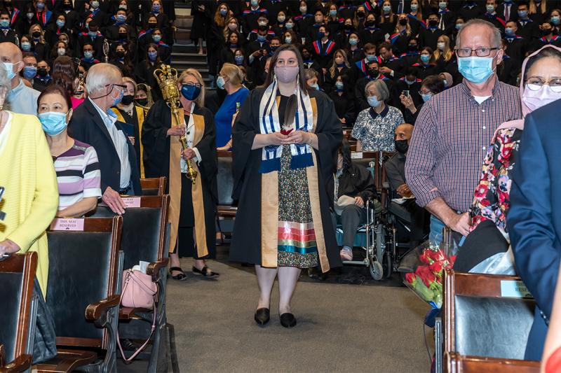 Lindsey Fechtig, holding the Eagle Feather in both hands, leads the convocation procession.