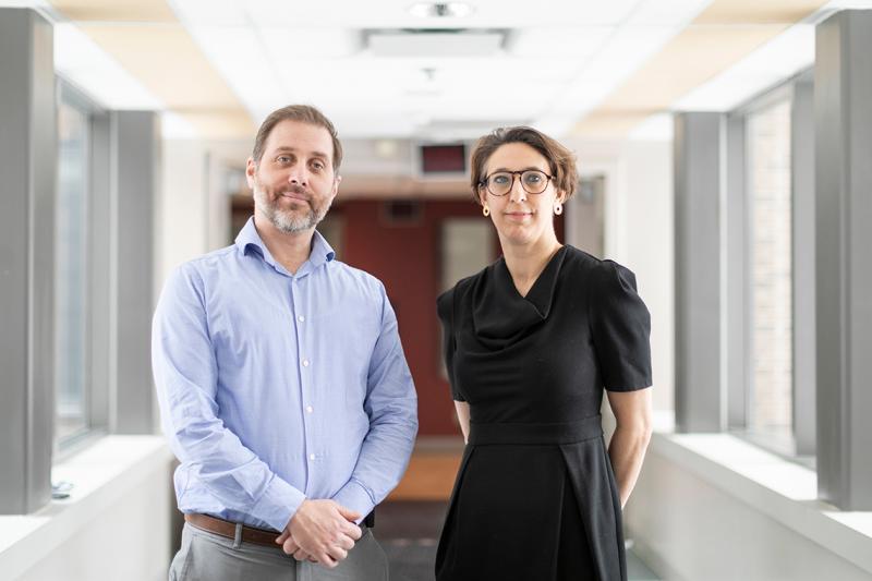 Robert Kozak and Samira Mubareka stand in a sunny hallway.