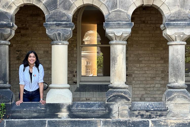 Renee standing between pillars of an old building