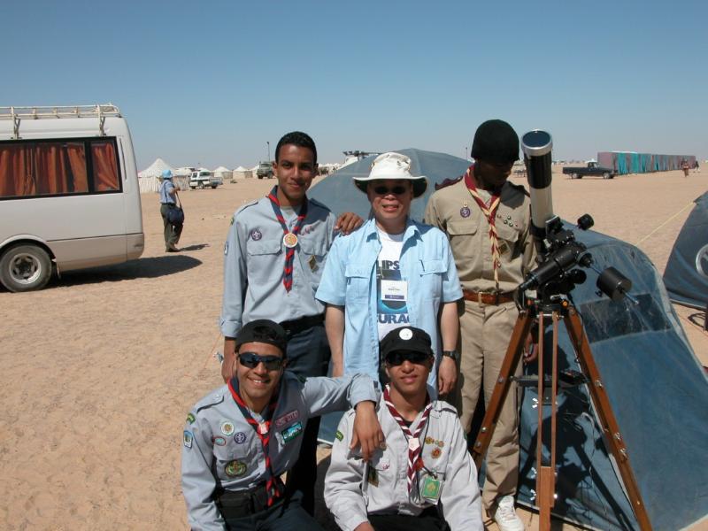 Ralph Chou standing outside in Libya with a group of boy scouts