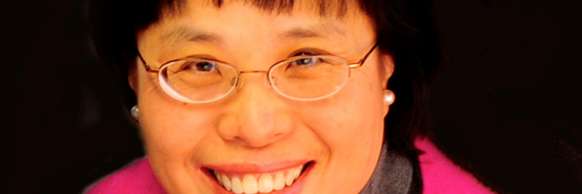 Carillonneur Tin-Shi Tam smiling in front of a black background.