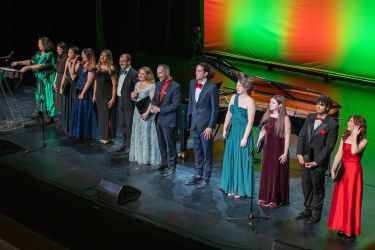 Singers standing in a row on stage at the end of the concert