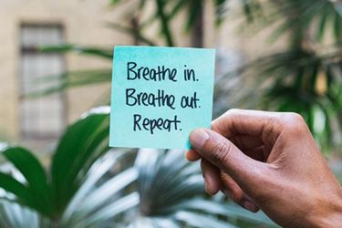 Post it note saying Breathe In, Breathe Out, Repeat