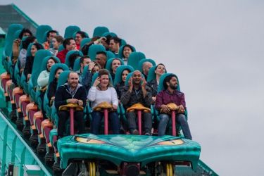 Several alumni riding a green roller coaster