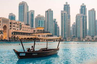 Dubai scene with boat in water and buildings in the background