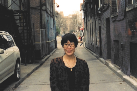 Christina Wong standing in a quiet alleyway.