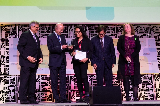 Reza Moridi, Ontario's minister of innovation, research and science, presents an award to U of T's Luna Yu (centre), the founder and CEO of Genecis EnviroTech, at this year's Discovery conference (photo by Chris Sorensen) 