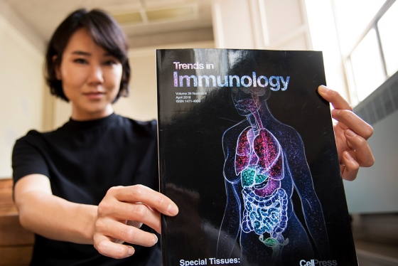 Shiz Aoki, the CEO of BioRender, holds up a journal whose cover art was made with her startup’s web-based software (photo by Chris Sorensen) 