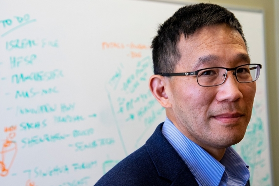 New Dean of U of T Engineering Christopher Yip stands in front of a whiteboard, looking thoughtful (photo by Chris Sorensen) 