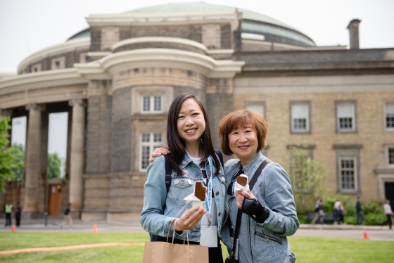 Mother and daughter enjoying ice cream sandwiches in front of Convocation Hall