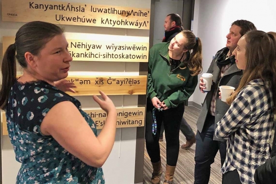 Rochelle Allan, left, acting manager of the Indigenous Initiatives Office, views the language installation -- five boards made from traditional wood and carved with Indigenous languages -- with U of T law students (photo by Lucianna Ciccocioppo) 