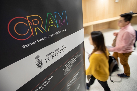 Two people walk into a lecture room near a sign advertising the CRAM festival at U of T (photo by Nick Iwanyshyn) 
