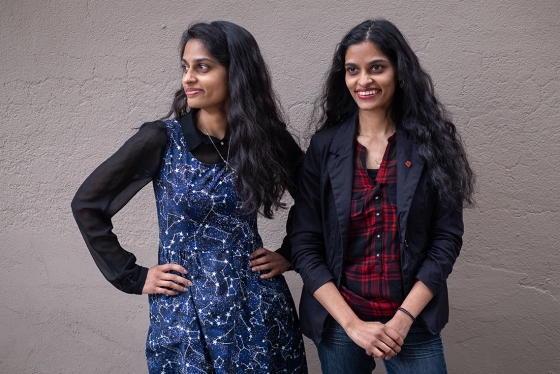 Identical twins Sandhya and Swapna Mylabathula stand side by side, smiling and laughing  (photo by Geoffrey Vendeville) 