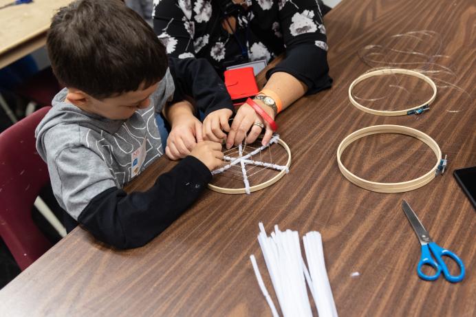 Child building an artificial spider's web 