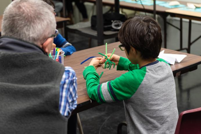 Child using pipe cleaners to build a spider 