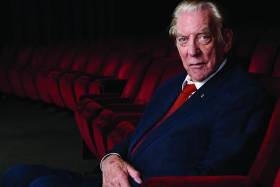 Portrait of Donald Sutherland sitting in a theatre