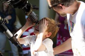 Little kid looking through telescope