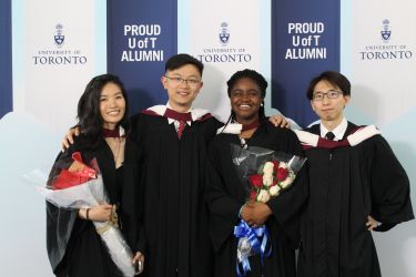 Group of new grad posing with their arms around each ohter's shoulders.