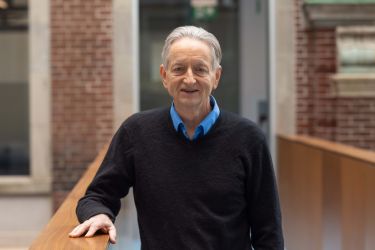 Prof. Hinton stands in a walkway in the Fitzgerald Building, U of T campus.