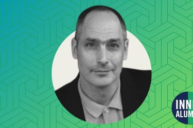 Black and white headshot of Professor Jeffrey Ian Ross displayed on a textured blue and green gradient background.