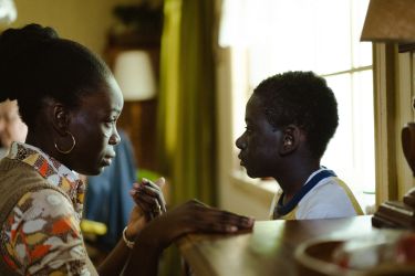 Rico (played by Rayan Dieudonné) and his mother, Erzulie (played by Penande Estime), talk next to a window.
