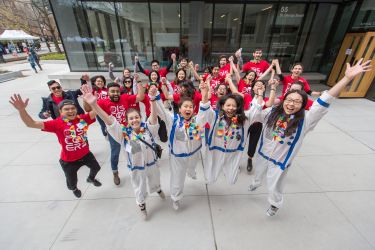 Image shows a group of student volunteers jumping in the air.