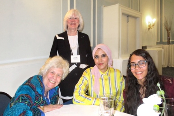 Members of University Women's Club Toronto smiling around a banquet table