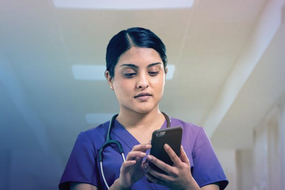 A medical professional uses a smartphone at work