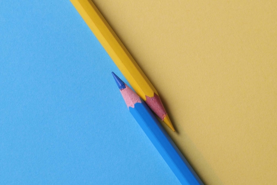 Yellow and blue pencil crayons on yellow and blue background.