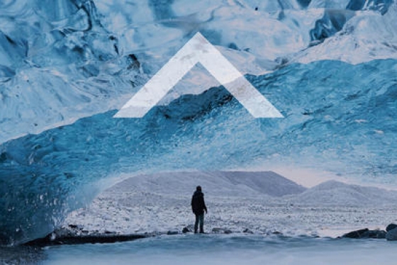 Image of ice glaciers and mountains with sole person in distance plus up arrow.