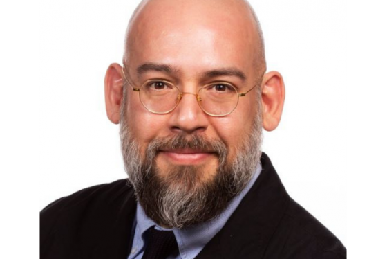 Speaker, Dr. Quiñonez, shown in close portrait, white male with glasses in suit.
