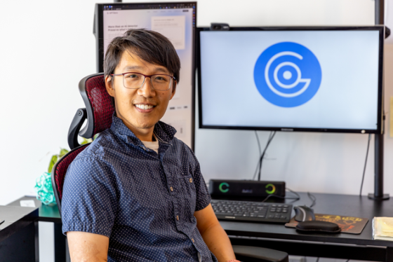 Alex Cui sitting in front of computer screens