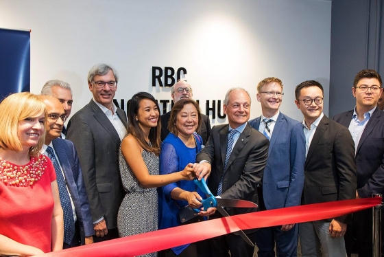 Entrepreneur Tricia Jose, Impact Centre Director Cynthia Goh and U of T President Meric Gertler cut the ribbon on U of T's new ONRamp facility as RBC CEO David McKay (fourth from left) and other U of T and RBC officials look on (photo by Chris Sorensen)