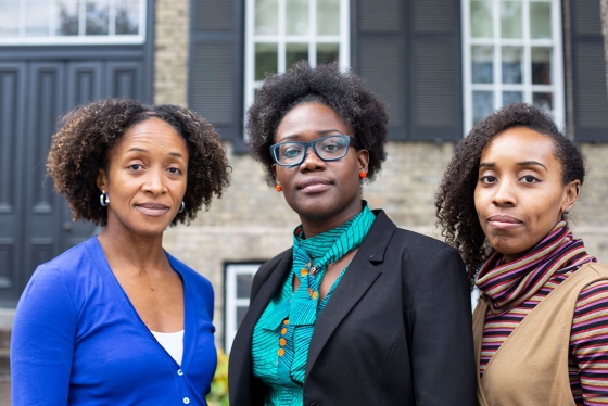 Aisha Lofters, Onye Nnorom and Nakia Lee-Foon stand outside a building, looking thoughtful.