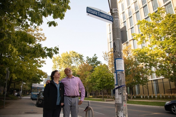 Siblings Monica and Martin Franklin look up at a sign on a light pole that reads: Ursula Franklin St.