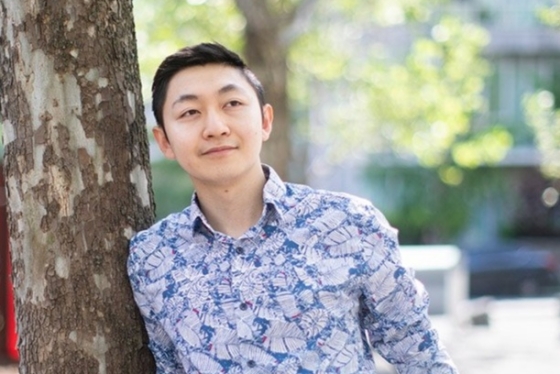 Portrait of Alex Lu leaning against a tree