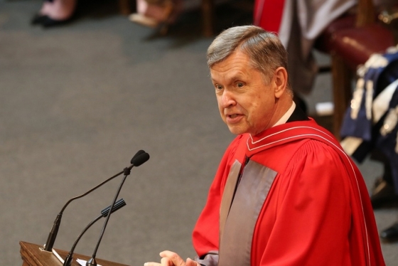 Alfred Aho talks while wearing academic robes and standing at a podium.