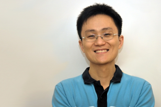 Photo of Allen Lu smiling in front of white wall