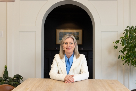 Melanie Woodin smiles while sitting behind a desk.