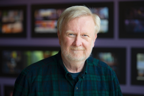 A portrait of Bill Reeves wearing a plaid shirt