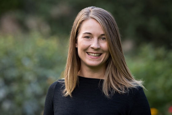 A portrait of Maaike Canrinus smiling in front of some greenery