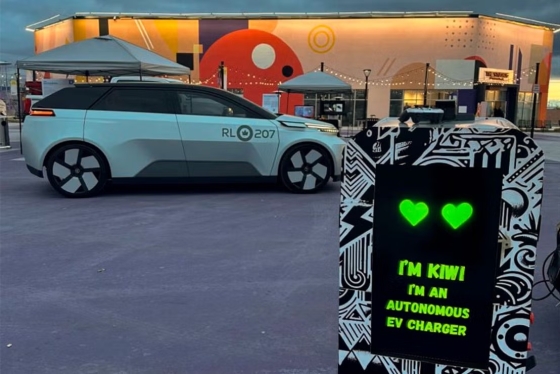 A car parked next to a Kiwi autonomous EV charger