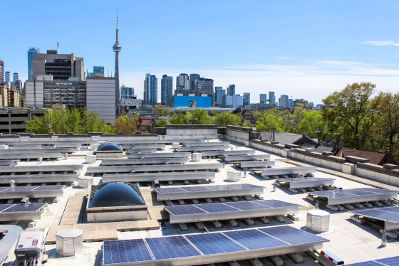 A rooftop at U of T is dotted with solar panel installations, angled to face south.