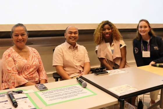 A panel of four people sitting at a desk