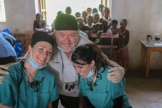 Courtney David, Elahe Behrooz and Izchak Barzilay smile with kids in Kabale, Uganda.